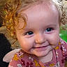 child, toddler, curly_hair, smile, blue_eyes, face, portrait, baby, cute, happy, indoors, clothing, floral_pattern, close_up, person, infant, young_child, cheeks, joy, innocence