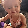 Athena joined the competition — help win amazing prizes! toddler, child, curly_hair, smiling, indoor, couch, person, face, baby_clothing, arm, light, window, tattoo, skin, portrait, happy, closeup, casual, young_child, home