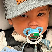 Jakai is registered to the contest to win money with this photo: baby, baby_boy, blanket, blue, cap, car_seat, child, close_up, clothing, comfort, cute, expression, face, headwear, indoors, infant, pacifier, safety, straps, young_child