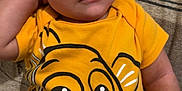 Jakai is registered to the contest to win money with this photo: baby, child, infant, onesie, yellow_clothing, face, hand, lying_down, patterned_blanket, cute, expression, curious, indoor, skin, person, young_child, smiling, cartoon_character, clothing, closeup