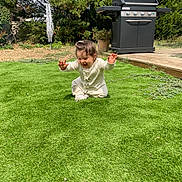 Loane participe au concours pour gagner de l'argent avec cette photo : backyard, barbecue_grill, child, fun, garden, grass, greenery, happy, lawn, nature, outdoor, pajamas, plant_pot, playing, sitting, smiling, sunlight, toddler, tree, young_child