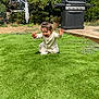 backyard, barbecue_grill, child, fun, garden, grass, greenery, happy, lawn, nature, outdoor, pajamas, plant_pot, playing, sitting, smiling, sunlight, toddler, tree, young_child