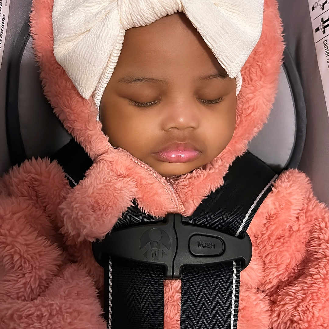 Malayah is registered to the contest to win money with this photo: bonnet, car, car_interior, carseat, clothing, cushion, doll, face, happy, hat, head, hood, person, photography, portrait, sleeping, smile, toy, transportation, vehicle