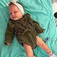 Laiklynn joined the competition — help win amazing prizes! baby, child, infant, headband, green_dress, ruffles, blanket, teal, socks, sneakers, white_shoes, cute, lying_down, indoors, soft_texture, portrait, small_hands, small_feet, clothing, person