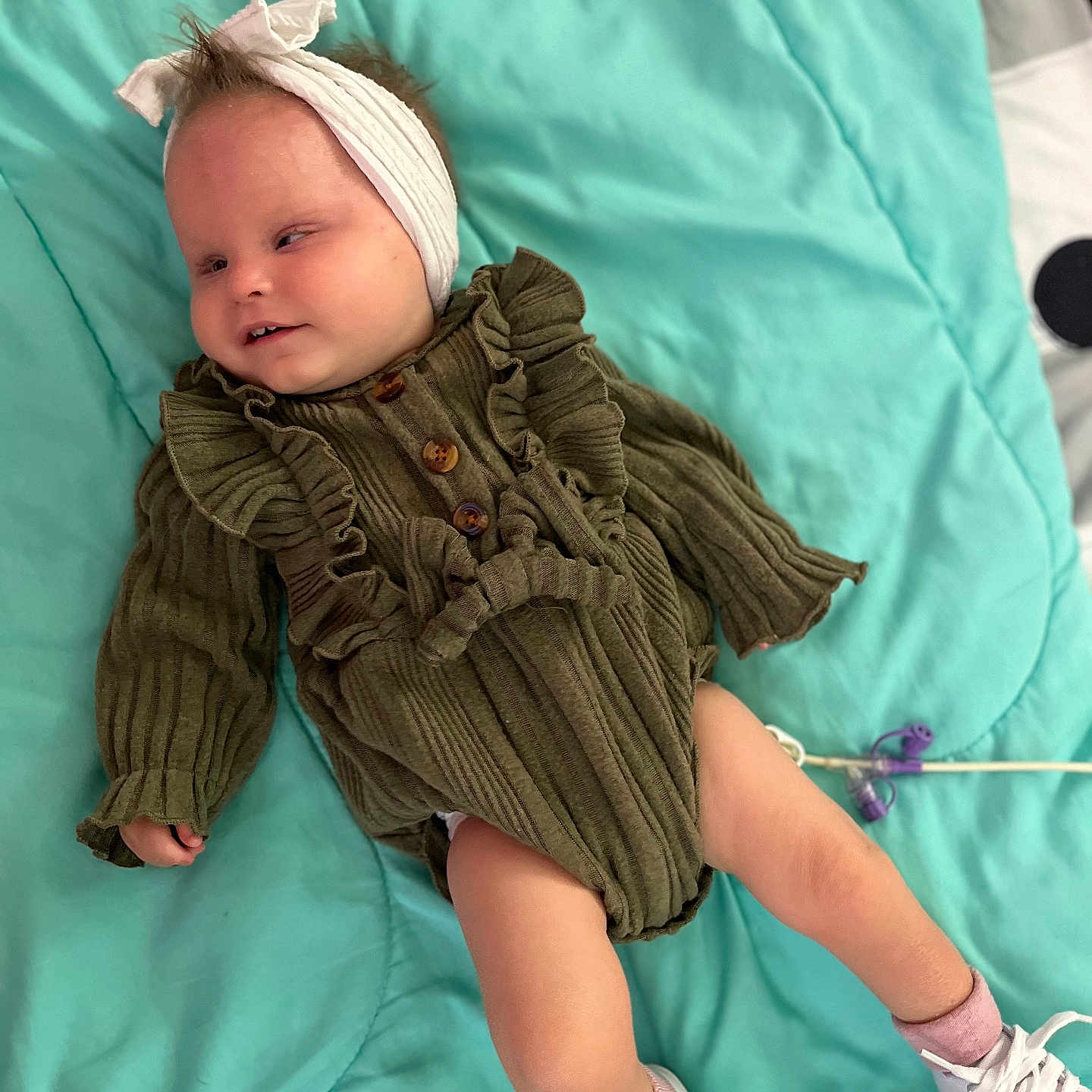 Laiklynn joined the competition — help win amazing prizes! baby, blanket, child, clothing, cute, green_dress, headband, indoors, infant, lying_down, person, portrait, ruffles, small_feet, small_hands, sneakers, socks, soft_texture, teal, white_shoes