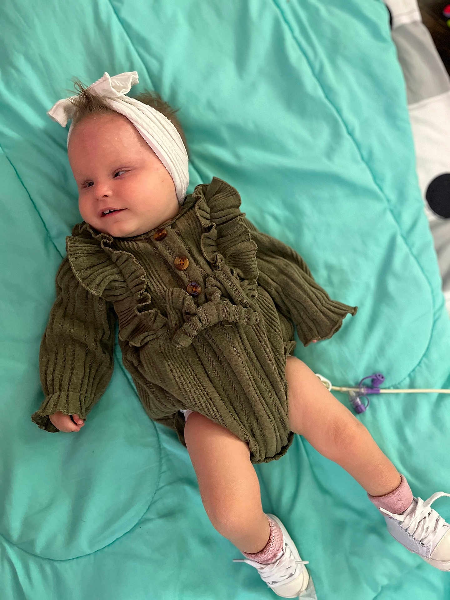 Laiklynn joined the competition — help win amazing prizes! baby, child, infant, headband, green_dress, ruffles, blanket, teal, socks, sneakers, white_shoes, cute, lying_down, indoors, soft_texture, portrait, small_hands, small_feet, clothing, person