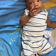 Jahylan participe au concours pour gagner de l'argent avec cette photo : baby, child, striped_clothing, sneakers, hand, bed, bedspread, blue, white, person, infant, cute, laying_down, young_child, indoor, resting, small_shoes, human, portrait, comfort