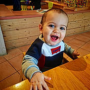 Téo a rejoint le concours — aidez-le/la à gagner de superbes lots ! toddler, smiling, child, indoor, wooden_table, sweater, levis, toy, playroom, furniture, happy, person, face, hand, table, floor, background, colorful, boys, play