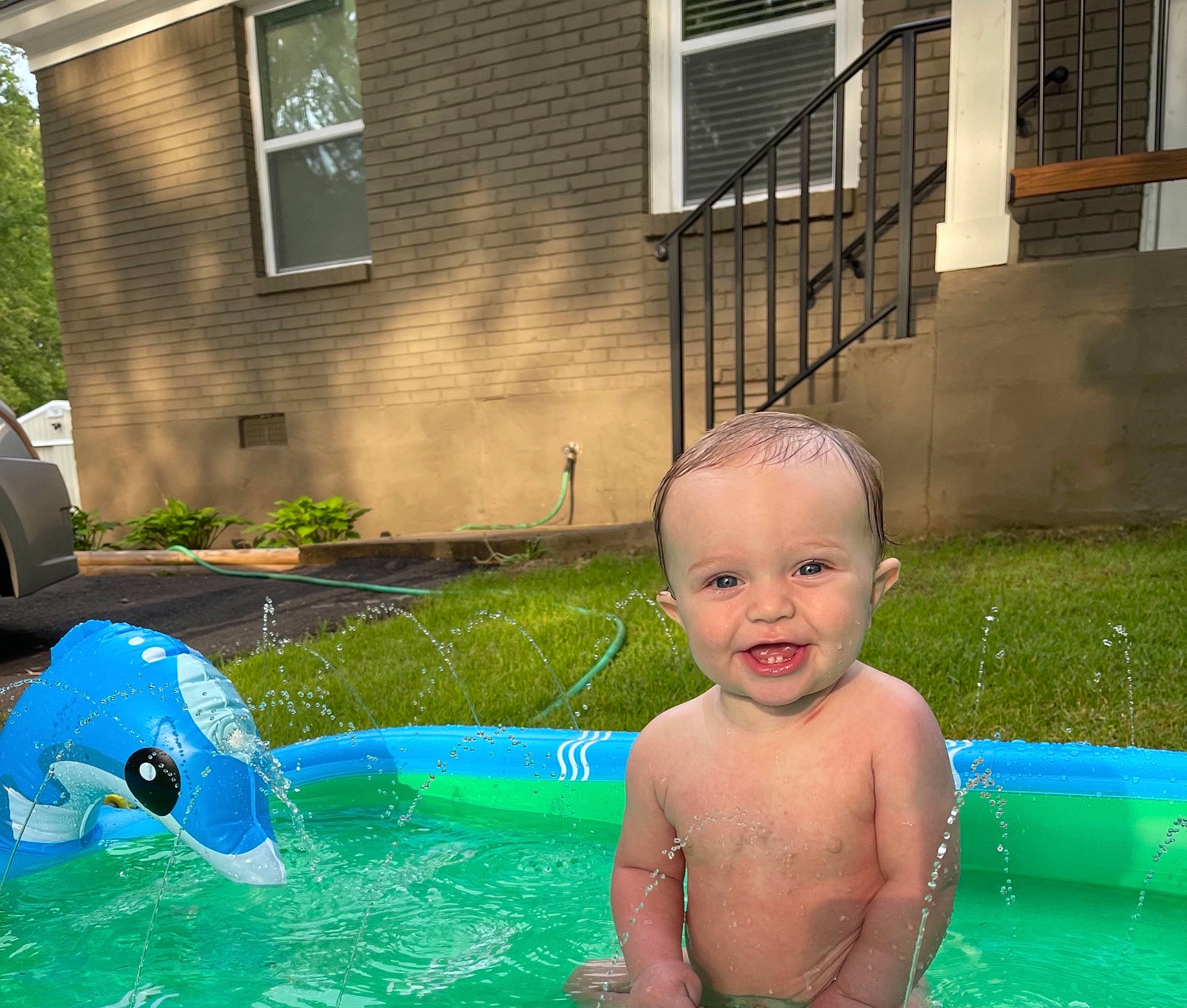 Kace is registered to the contest to win money with this photo: baby, barechested, bathing, chest, fun, games, grass, happy, inflatable, lawn, leisure, person, plant, recreation, smile, summer, swimming_pool, swimwear, toddler, water