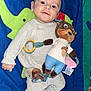baby, child, infant, toy, stuffed_animal, play_mat, blue, green, yellow, smiling, cozy_clothing, white_socks, lying_down, cute, happy, indoors, soft_texture, colorful, playful, portrait
