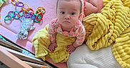 Taylynn joined the competition — help win amazing prizes! baby, infant, blanket, pink, yellow_blanket, toy, rings, soft_toys, crib, play_area, child, crawling, cute, indoors, face, person, clothing, head, looking_up, floor