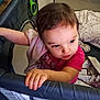 Riley is registered to the contest to win money with this photo: toddler, child, playpen, blanket, cloth, hand, face, curious, indoors, baby, grip, furniture, person, pink_clothing, young_child, expression, soft_toy, sleeping_area, home, portrait