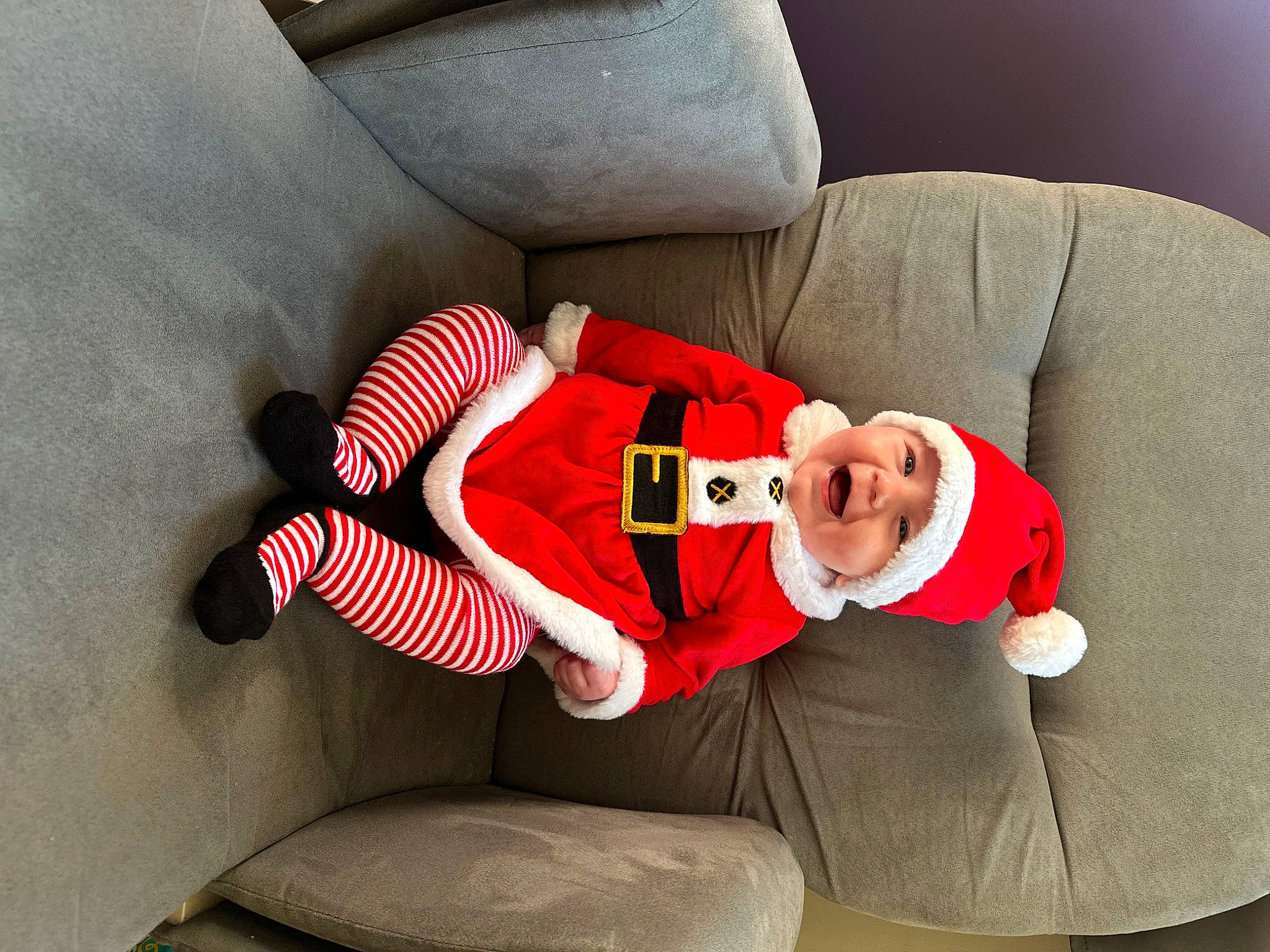 Astrid is registered to the contest to win money with this photo: baby, baby_toddler_clothing, carmine, child, comfort, couch, elbow, event, hat, headwear, human_leg, knee, lap, leg, person, red, sitting, sleeve, sock, sportswear