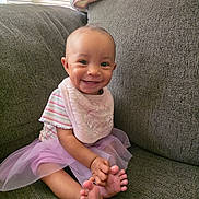 Honestii joined the competition — help win amazing prizes! baby, smiling, tutu, pink, striped_shirt, bib, couch, indoor, happy, child, window_blinds, feet, toes, seated, cute, person, portrait, soft_light, home, furniture