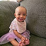baby, smiling, tutu, pink, striped_shirt, bib, couch, indoor, happy, child, window_blinds, feet, toes, seated, cute, person, portrait, soft_light, home, furniture