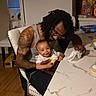 Honestii joined the competition — help win amazing prizes! baby, man, tattoo, cupcake, food, kitchen, table, chair, smile, dreadlocks, glasses, napkin, happy, indoor, person, parent, child, family, celebration, sweet