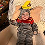 Nathaniel is registered to the contest to win money with this photo: baby, child, costume, dumbo, elephant, smile, cute, indoors, chair, knit_blanket, plush, footwear, red, yellow, gray, happy, young, person, seated, soft