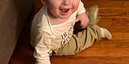 Nathaniel is registered to the contest to win money with this photo: toddler, child, smiling, happy, floor, wooden_floor, couch, indoor, clothing, long_sleeve, pants, person, baby, face, expression, sitting, playful, home, young_child, casual