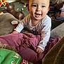 Nathaniel joined the competition — help win amazing prizes! toddler, child, smiling, indoor, living_room, couch, toys, playful, happy, clothing, blanket, furniture, person, face, baby, expression, curious, head, hand, casual