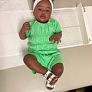 Leilani is registered to the contest to win money with this photo: toddler, child, green_outfit, white_sandals, headband, medical_table, clinic, floor, measuring_device, person, feet, indoors, baby, cute, lying_down, portrait, skin, hands, face, expression