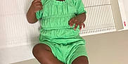 Leilani is registered to the contest to win money with this photo: toddler, child, green_outfit, white_sandals, headband, medical_table, clinic, floor, measuring_device, person, feet, indoors, baby, cute, lying_down, portrait, skin, hands, face, expression