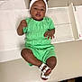 toddler, child, green_outfit, white_sandals, headband, medical_table, clinic, floor, measuring_device, person, feet, indoors, baby, cute, lying_down, portrait, skin, hands, face, expression