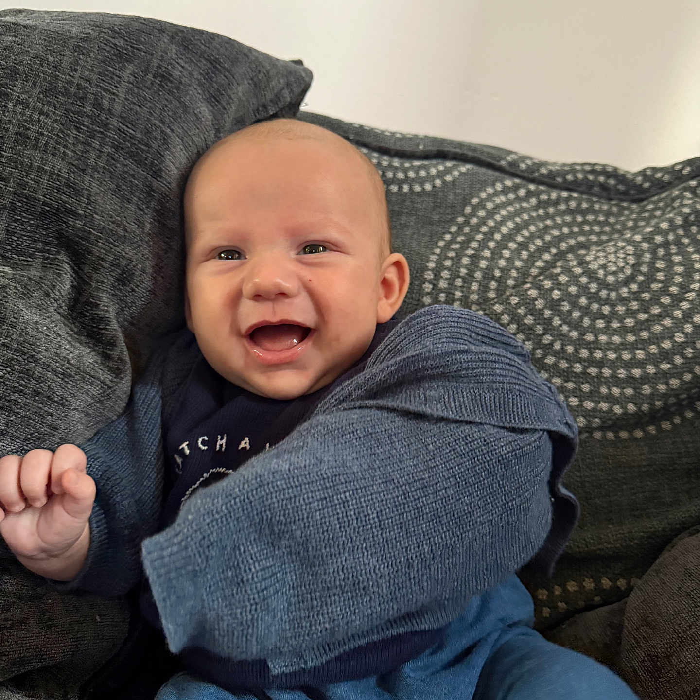 Noah joined the competition — help win amazing prizes! baby, blue_clothing, child, comfort, couch, cozy, cute, face, happy, head, home, indoor, infant, knitted_sweater, person, pillow, portrait, sitting, smiling, young_child