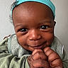 Joel is registered to the contest to win money with this photo: baby, child, face, smile, hands, headband, clothing, portrait, cute, closeup, happy, infant, skin, eyebrows, eyes, fingers, sleeves, person, young, indoors