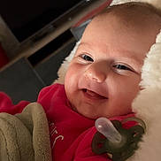 Victoria participe au concours pour gagner de l'argent avec cette photo : baby, smiling, pacifier, blanket, red_clothing, cozy, cushion, face, infant, child, indoors, soft_texture, happy, portrait, cute, lying_down, close_up, warm, comfort, baby_girl