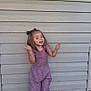 barefoot, casual_clothing, child, cute, daylight, expression, full_body, girl, happy, joy, long_hair, outdoor, playful, posing, purple_outfit, smiling, standing, tile_floor, wooden_wall, young
