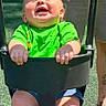 Elliott is registered to the contest to win money with this photo: baby, child, infant, stroller, smiling, laughing, outdoor, green_shirt, shorts, sitting, safety_bar, sunlight, playground, adult_hand, portrait, happy, face, legs, family, park