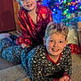 child, children, pajamas, smiling, indoor, christmas_tree, holiday_lights, carpet, playful, family, home, decorations, happy, blonde_hair, curly_hair, portrait, cute, festive, celebration, together