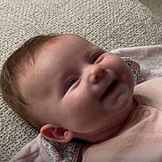 Freya is registered to the contest to win money with this photo: baby, blanket, cheeks, child, clothing, cute, ear, fabric, face, happy, head, indoors, infant, lying_down, portrait, skin, smiling, soft_lighting, texture, toddler