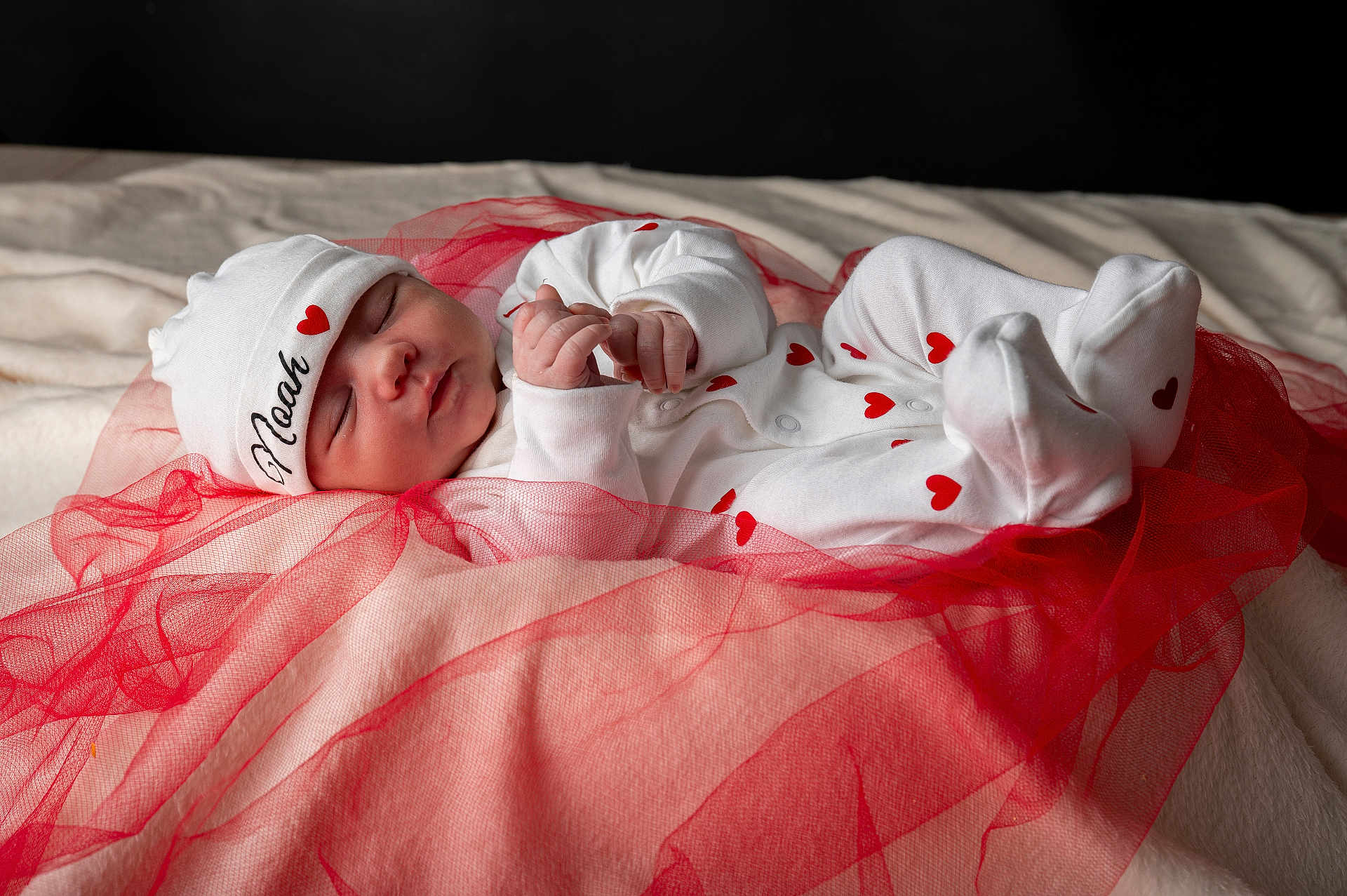 Noah a rejoint le concours — aidez-le/la à gagner de superbes lots ! baby, newborn, sleeping, infant, white_clothing, red_hearts, hat, soft_blanket, red_netting, peaceful, cute, portrait, cozy, sleep, hand, footed_pajamas, lying_down, closeup, child, resting