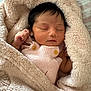newborn, baby, sleeping, blanket, pink_clothing, soft_texture, infant, cozy, cute, peaceful, wrapped, knitted, wooden_buttons, skin, small_hands, indoors, closeup, resting, toddler, portrait
