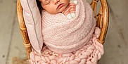 Raelynn is registered to the contest to win money with this photo: newborn, baby, sleeping, pink, blanket, headband, flower_crown, wicker_chair, stuffed_toy, soft_texture, cozy, portrait, flower_arrangement, pastel_colors, cute, infant, wrapped, peaceful, indoor, decorative