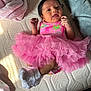 Raelynn joined the competition — help win amazing prizes! baby, infant, pink_tutu, colorful_clothing, white_socks, mattress, blanket, soft_texture, cute, small_hands, lying_down, indoors, portrait, child, adorable, happy_expression, newborn, sleepwear, fabric, cozy