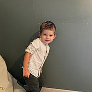 Nolan participe au concours pour gagner de l'argent avec cette photo : child, boy, smiling, shirt, pants, indoor, wall, floor, bean_bag, happy, portrait, standing, casual_clothing, young, cute, home, leaning, light, wood_floor, cozy