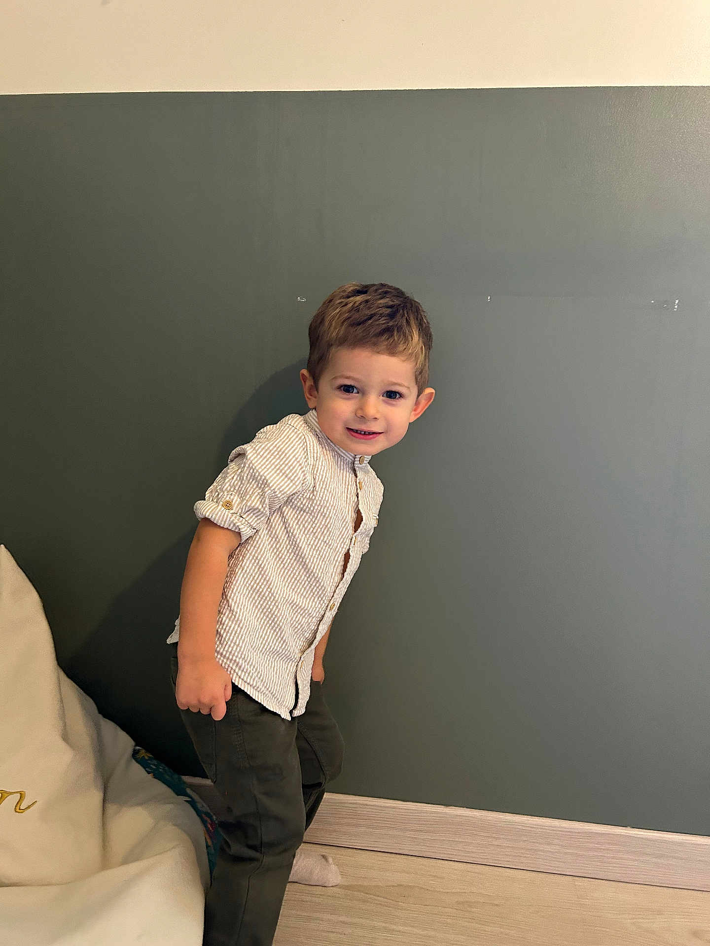 Nolan participe au concours pour gagner de l'argent avec cette photo : child, boy, smiling, shirt, pants, indoor, wall, floor, bean_bag, happy, portrait, standing, casual_clothing, young, cute, home, leaning, light, wood_floor, cozy