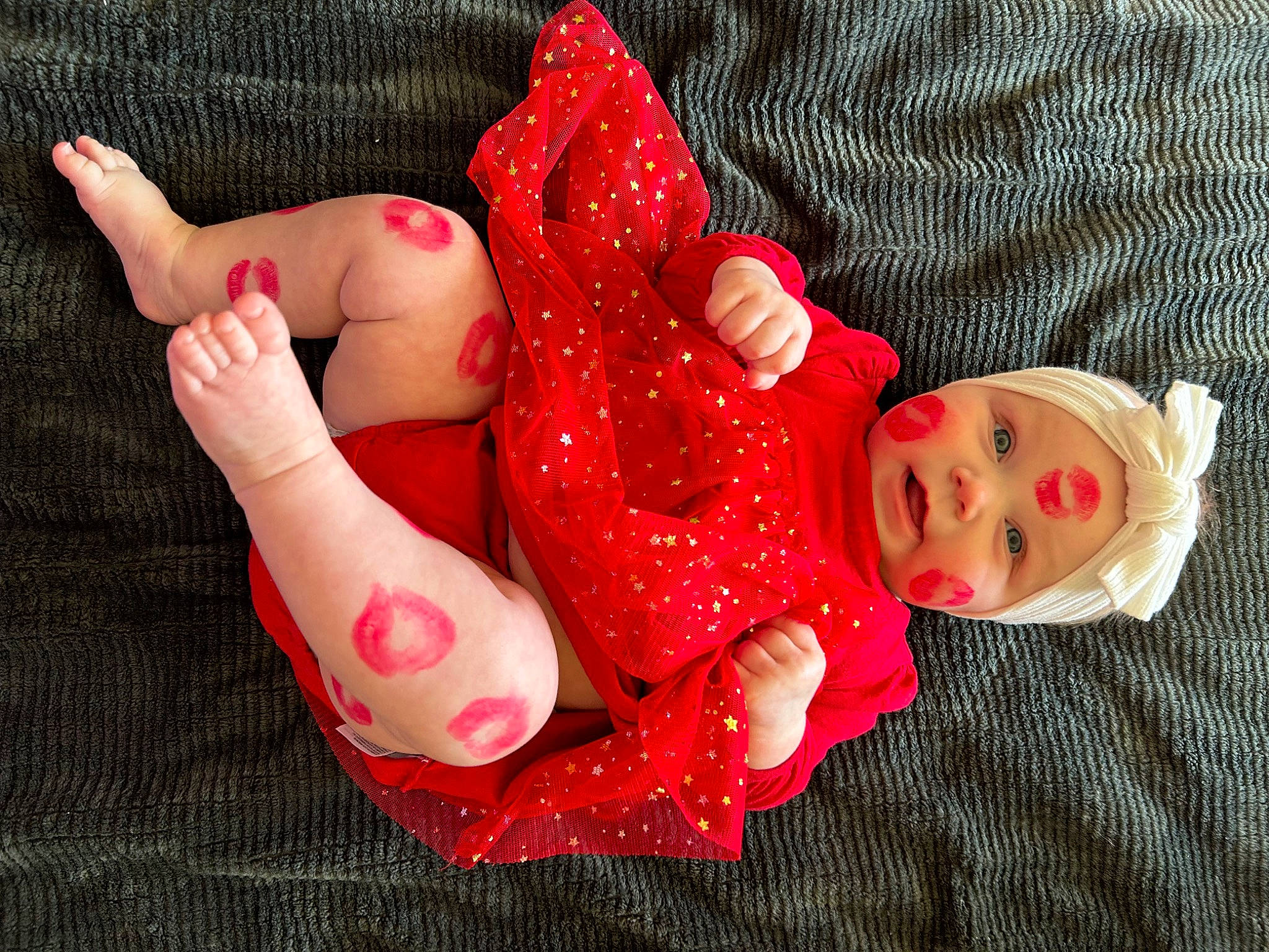 Elise is registered to the contest to win money with this photo: arm, baby_toddler_clothing, barefoot, child, dress, finger, foot, gesture, hand, headwear, human_body, joint, lip, nail, person, pink, red, skin, thigh, thumb