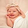 baby, infant, smile, headband, bow, blanket, soft_texture, pink, white, happy, cute, face, skin, newborn, lying_down, portrait, child, person, indoors, cozy