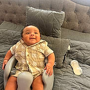 Tay is registered to the contest to win money with this photo: baby, infant, smiling, baby_chair, couch, pillow, bottle, indoor, clothing, happy, child, person, seat, furniture, curtain, soft_lighting, cute, home, relaxing, portrait