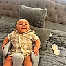 baby, infant, smiling, baby_chair, couch, pillow, bottle, indoor, clothing, happy, child, person, seat, furniture, curtain, soft_lighting, cute, home, relaxing, portrait