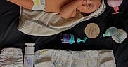 Tay is registered to the contest to win money with this photo: baby, infant, diaper, towel, baby_care, skin, hand, face, lying_down, product_bottle, baby_lotion, baby_powder, black_background, newborn, child, cute, baby_skin, baby_supplies, personal_care, sucking_fingers