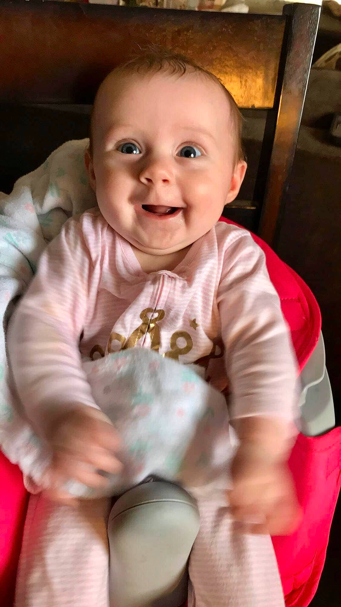 Lila is registered to the contest to win money with this photo: baby, baby_laughing, cheek, child, face, facial_expression, head, laugh, lip, person, pink, play, sitting, skin, smile, toddler