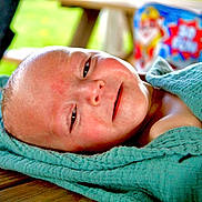 Dawson is registered to the contest to win money with this photo: baby, towel, wood, wrapped, sleepy, smile, face, skin, infant, child, closeup, indoors, colorful, background, texture, relaxing, portrait, person, soft, cute