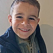 Tommy participe au concours pour gagner de l'argent avec cette photo : child, boy, smile, face, portrait, clothing, sweater, vest, hair, young, happy, indoors, casual, person, head, cute, friendly, light, background, fashion