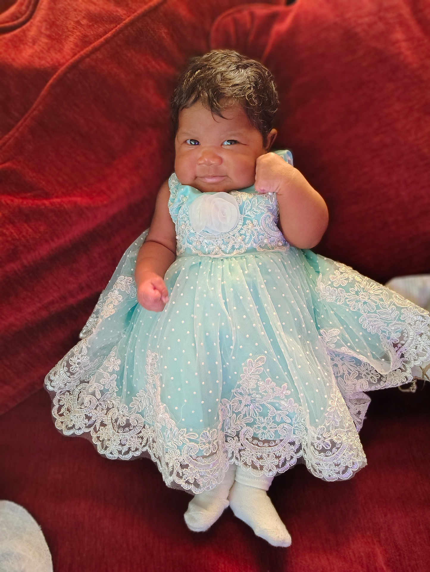 Malliah joined the competition — help win amazing prizes! baby, child, dress, lace, mint_green, couch, red, sock, smile, fist, cute, portrait, indoor, infant, sitting, fabric, clothing, person, young, cozy