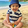 baby, child, toddler, beach, sand, ocean, smiling, navy_hat, striped_onesie, toy, sitting, barefoot, portrait, vacation, summer, smile, cute, happy, coastline, sand_toys