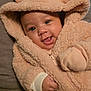baby, blanket, bonnet, clothing, face, happy, hat, head, hood, hoodie, knitwear, newborn, person, photography, portrait, quilt, smile, sweater, sweatshirt, towel